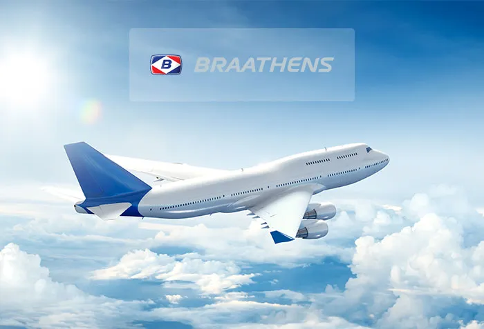 Flygplan ovanför molnen med Braathens logga