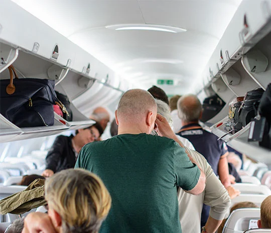 Hatthyllor med handbagage på ett flygplan