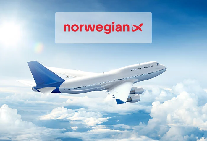 Flygplan ovanför molnen med Norwegians logga